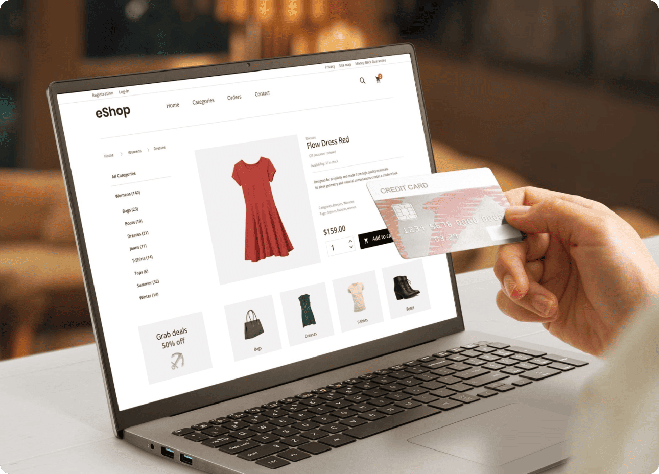Personne effectuant un achat en ligne d'une robe sur un site e-commerce avec sa carte de crédit devant un ordinateur portable.