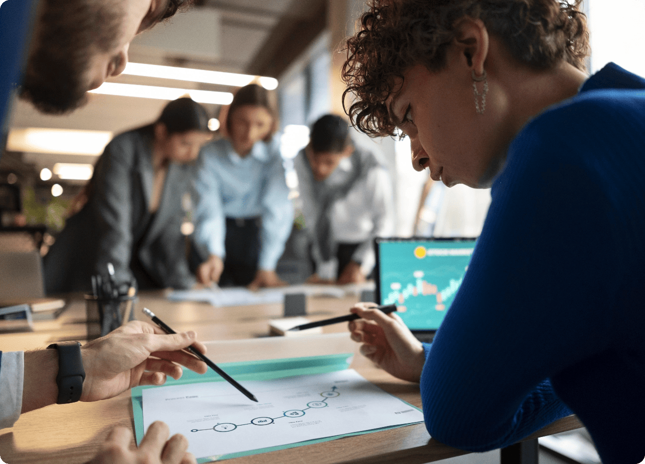 Vue de dessus d'une équipe de collaborateurs joignant leurs mains au centre en signe de cohésion, de motivation et de travail d'équipe.